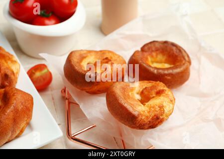 Griglia di raffreddamento con gustoso budino dello Yorkshire su sfondo piastrellato leggero Foto Stock