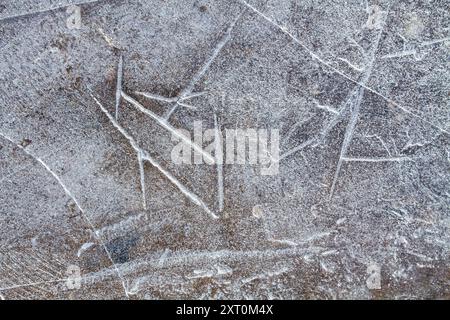 Superficie di ghiaccio modellata formata da crepe e solchi. Primo piano. Sfondo invernale astratto per Natale. Foto Stock