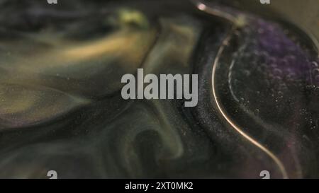 Liquido frizzante. Inchiostro di lusso. Colore nero dorato sfocato che mescola particelle glitter vernice scintillante bolle d'olio galleggianti movimento flusso sfondo artistico astratto. Foto Stock