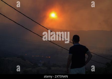 Atene, Grecia. 12 agosto 2024. I residenti stanno guardando il fronte del fuoco mentre si avvicina al sobborgo di Penteli della capitale greca. Un incendio che scoppiò a Varnavas l'11 agosto continuò a infuriare nell'Attica orientale il 12 agosto, si diffuse e si diffuse su un fronte che si estendeva per più di 20 chilometri. Diversi paesi hanno risposto positivamente alla richiesta delle autorità greche di assistenza da parte del meccanismo di protezione civile dell'UE (EUCPM) per combattere l'infuria degli incendi. Crediti: Dimitris Aspiotis/Alamy Live News Foto Stock