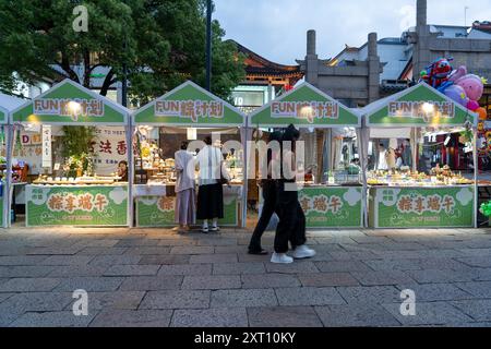 Suzhou, Cina - 11 giugno 2024: Una scena serale di strada a Suzhou, in Cina, con bancarelle che vendono vari prodotti e prodotti alimentari. Foto Stock