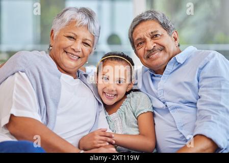 Nonni, ragazza e felice in casa in ritratto sul divano per amore, sostegno e legame come pensionati. Gente, famiglia e sorrisi per una visita sul divano Foto Stock