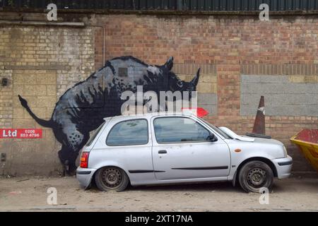 Londra, Inghilterra, Regno Unito. 12 agosto 2024. Una nuova opera d'arte di Banksy appare su un muro a Charlton, Londra, raffigurante un rinoceronte che si intima con un'auto con un cono stradale sul cofano. Questa è l'ottava nuova opera d'arte in altrettanti giorni nella capitale da parte dell'elusivo artista di strada. (Credit Image: © Vuk Valcic/ZUMA Press Wire) SOLO PER USO EDITORIALE! Non per USO commerciale! Foto Stock