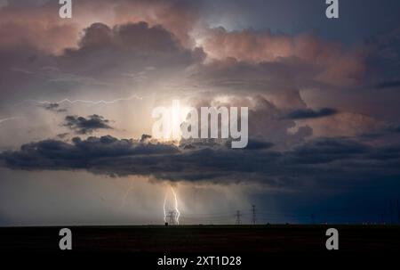 Una tempesta illumina il cielo con un potente fulmine vicino alle torri di trasmissione al tramonto. Post, Texas Stati Uniti peja00036 Copyright: X Foto Stock