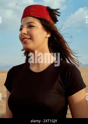 Donna sorridente con bandana rossa e camicia nera in piedi all'aperto con un cielo limpido sullo sfondo. Bola02604 Copyright: XConnectxImagesx Foto Stock