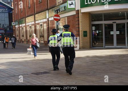 Hull, East Yorkshire, Regno Unito 13 agosto 2024. Ci sono stati 61 arresti con 22 accusati, e tre condannati con l'accusa di disordini violenti in mezzo a rivolte a Hull 10 giorni fa. Altri rimangono in custodia, in attesa di condanna. I negozi lungo Jameson St (direttamente di fronte alla stazione ferroviaria) e il Royal Hotel, che si credeva ospitasse i rifugiati, avevano le finestre rotte e furono saccheggiate. I negozi rimangono a bordo. Shoezone che ha subito più danni, è chiusa a tempo indeterminato. Oggi, la vita continua, con una maggiore presenza della polizia. Bridget Catterall AlamyLiveNews Foto Stock