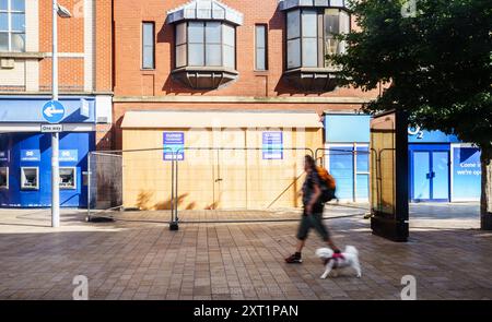 Hull, East Yorkshire, Regno Unito 13 agosto 2024. Ci sono stati 61 arresti con 22 accusati, e tre condannati con l'accusa di disordini violenti in mezzo a rivolte a Hull 10 giorni fa. Altri rimangono in custodia, in attesa di condanna. I negozi lungo Jameson St (direttamente di fronte alla stazione ferroviaria) e il Royal Hotel, che si credeva ospitasse i rifugiati, avevano le finestre rotte e furono saccheggiate. I negozi rimangono a bordo. Shoezone che ha subito più danni, è chiusa a tempo indeterminato. Oggi, la vita continua, con una maggiore presenza della polizia. NELLA FOTO: Shoezone ha chiuso Bridget Catterall AlamyLiveNews Foto Stock