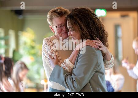 Gioioso abbraccio tra due donne che condividono un momento di felicità e affetto in casa. Panc05584 Copyright: XConnectxImagesx Foto Stock