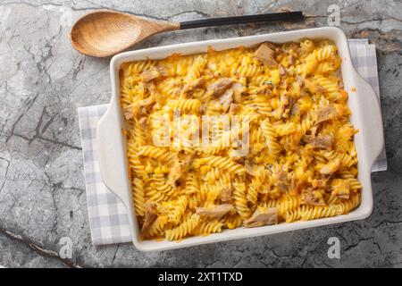 Pasta al tonno in scatola cotta al forno con salsa mornay da vicino in un piatto da forno sul tavolo. Vista dall'alto orizzontale Foto Stock