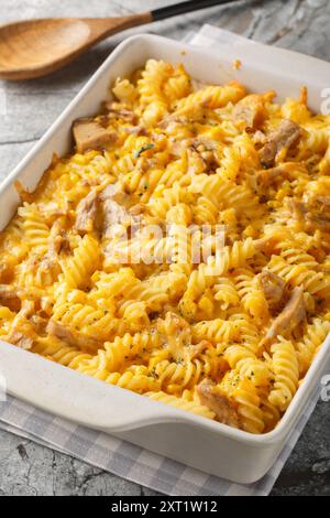 Pasta cremosa di tonno Mornay con pasta di tonno, primo piano sul piatto da forno sul tavolo. Verticale Foto Stock