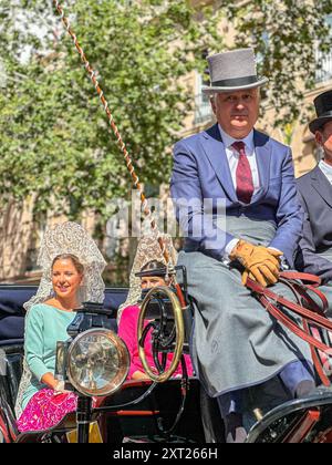 La Fiera di Siviglia nota come Fiera de Abril si tiene a Siviglia, Andalusia per una settimana. Le donne indossano abiti flamenco e gli uomini con abiti eleganti per la festa Foto Stock