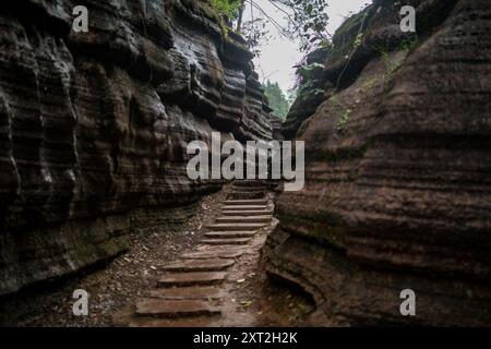 Stretto sentiero in pietra che si snoda attraverso formazioni rocciose che conducono verso l'alto in un ambiente naturale isolato Foto Stock