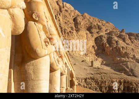 La colossale statua di Osiride, il dio egizio dell'aldilà, fa la guardia sul tempio funerario della regina Hatshepsut a Luxor. La sua presenza. Foto Stock