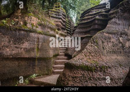 Stretto sentiero in pietra che si snoda attraverso formazioni rocciose che conducono verso l'alto in un ambiente naturale isolato Foto Stock