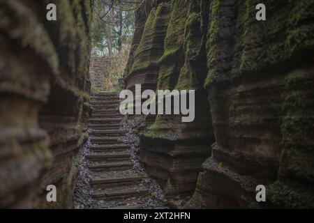 Stretto sentiero in pietra che si snoda attraverso formazioni rocciose che conducono verso l'alto in un ambiente naturale isolato Foto Stock