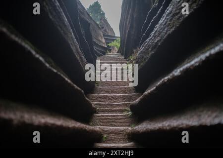 Stretto sentiero in pietra che si snoda attraverso formazioni rocciose che conducono verso l'alto in un ambiente naturale isolato Foto Stock