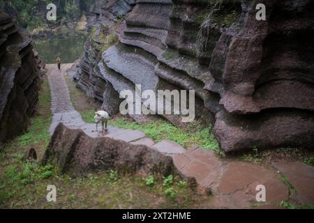 Stretto sentiero in pietra che si snoda attraverso formazioni rocciose che conducono verso l'alto in un ambiente naturale isolato Foto Stock
