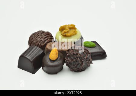 Diversi tipi di praline al cioccolato, primo piano, isolate su sfondo bianco Foto Stock