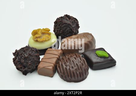 Diversi tipi di praline al cioccolato, primo piano, isolate su sfondo bianco Foto Stock