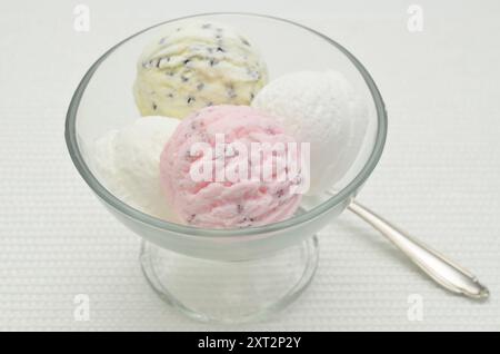 Cucchiai di gelato in un recipiente di vetro, da vicino, isolato su sfondo bianco Foto Stock