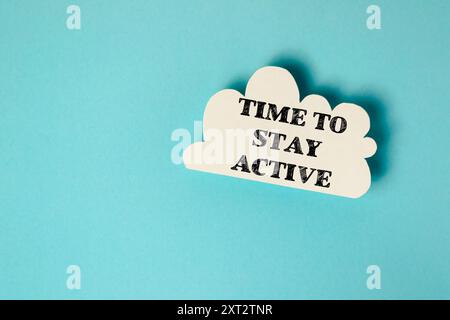 Una nuvola bianca con le parole Time to Stay Active scritte su di essa. Concetto di motivazione e incoraggiamento a rimanere attivi e sani Foto Stock