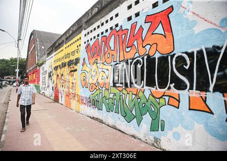 Reazioni alle dimissioni di Sheikh Hasina Wajed a Dhaka, Bangladesh, Uno studente dipinge un nuovo graffito su un muro di strada nel campus dell'Università di Dhaka a Dhaka, Bangladesh, 13 agosto 2024. In un discorso alla nazione, il 5 agosto 2024 il capo di stato maggiore dell'esercito generale Waker-Uz-Zaman ha annunciato le dimissioni del primo ministro Sheikh Hasina dopo settimane di disordini. Il premio Nobel Muhammad Yunus ha prestato giuramento come capo del governo ad interim del Bangladesh l'8 agosto 2024 dopo che lo sceicco Hasina si è dimesso e ha lasciato il paese in mezzo a violente proteste sul sistema di quote di lavoro del governo. Dhaka Distretto di Dhaka Bangladesh Co Foto Stock