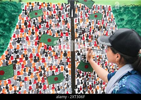 Reazioni alle dimissioni di Sheikh Hasina Wajed a Dhaka, Bangladesh, Uno studente dipinge un nuovo graffito su un muro di strada nel campus dell'Università di Dhaka a Dhaka, Bangladesh, 13 agosto 2024. In un discorso alla nazione, il 5 agosto 2024 il capo di stato maggiore dell'esercito generale Waker-Uz-Zaman ha annunciato le dimissioni del primo ministro Sheikh Hasina dopo settimane di disordini. Il premio Nobel Muhammad Yunus ha prestato giuramento come capo del governo ad interim del Bangladesh l'8 agosto 2024 dopo che lo sceicco Hasina si è dimesso e ha lasciato il paese in mezzo a violente proteste sul sistema di quote di lavoro del governo. Dhaka Distretto di Dhaka Bangladesh Co Foto Stock