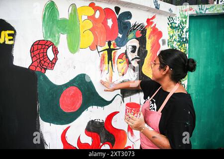 Reazioni alle dimissioni di Sheikh Hasina Wajed a Dhaka, Bangladesh, Uno studente dipinge un nuovo graffito su un muro di strada nel campus dell'Università di Dhaka a Dhaka, Bangladesh, 13 agosto 2024. In un discorso alla nazione, il 5 agosto 2024 il capo di stato maggiore dell'esercito generale Waker-Uz-Zaman ha annunciato le dimissioni del primo ministro Sheikh Hasina dopo settimane di disordini. Il premio Nobel Muhammad Yunus ha prestato giuramento come capo del governo ad interim del Bangladesh l'8 agosto 2024 dopo che lo sceicco Hasina si è dimesso e ha lasciato il paese in mezzo a violente proteste sul sistema di quote di lavoro del governo. Dhaka Distretto di Dhaka Bangladesh Co Foto Stock