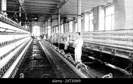 Filatura del cotone in filato: Un grande mulo da filatura in uso, 1909. Barlow e Jones di Manchester era "...una delle più antiche aziende dell'industria del cotone...che, limitandosi esclusivamente alla produzione di cotone e di cotone, si è affermata una posizione preminente e ha costruito un commercio che si estende su tutto il mondo". Da "Illustrated London News", 1909. Foto Stock