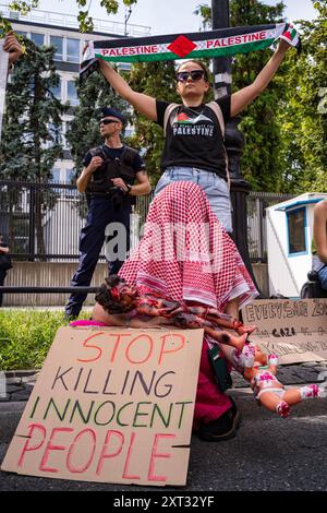 Un manifestante mostra un cartello e bambole smembrate fuori dall'ambasciata americana durante la dimostrazione. Il 3 agosto 2024, il genocidio in corso perpetrato da Israele in Palestina ha raggiunto 300 giorni, manifestanti pro-palestinesi protestano marciando attraverso Varsavia. Portando con sé cartelli e bandiere, i manifestanti camminarono dal Castello reale di Varsavia a Plac Zamkowy passando davanti al Palazzo Presidenziale e all'Università di Varsavia verso la loro destinazione, l'Ambasciata americana. Foto Stock