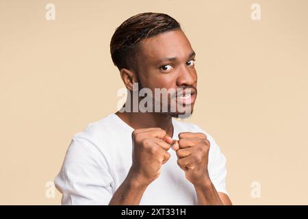 Ragazzo nero Clenching pugni pronti a lottare in piedi, Studio Shot Foto Stock