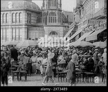 Scena del film "il marito obbligatorio": Folle di vacanzieri seduti nei caffè all'aperto degli anni '1920 "I visitatori di Deauville negli anni Venti potrebbero aver capito che era un posto piuttosto sfarzoso e rispettabile. AHA, ma non proprio la Deauville del paravento d'argento. Da Time to Remember - Came the Dawn, 1925 (Reel 3); dai un'occhiata all'industria cinematografica britannica degli anni '1920 - clip di grandi film muti e notiziari. Foto Stock