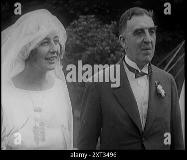 Sposa e sposo in piedi per le fotografie, 1921. Da "Time to Remember - The Time When Little Happened", 1921 (Reel 1); eventi del 1921 - trattato irlandese, acrobazie pazze e giornali al lavoro. Foto Stock