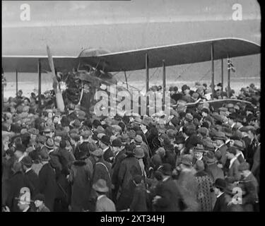 Un gruppo numeroso di persone affollate intorno all'aeroplano di Sir Alan Cobham lo saluta al suo ritorno dall'Australia nel 1926. Da "Time to Remember 1926 - Short Sharp Shower" ( Reel 2); documentario sul 1926 - General Strike, politica internazionale, danza, meteo e imprese da record. Foto Stock