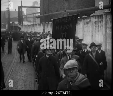 I manifestanti che portano uno striscione che recita: "Miners March to London", 1931. I manifestanti della fame. Duecentomila disoccupati, scortando una petizione firmata da un milione di persone, una richiesta di abolizione del test dei mezzi. La richiesta di qualcuno, da qualche parte, di fare qualcosa per i camion del carbone vuoti, e i conseguenti stomaci vuoti”. Da Time to Remember - A New era, 1931 (Reel 1); documentario sul mondo nei primi anni '1930 Foto Stock