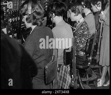Donne civili che lavorano all'International Telephone Exchange, 1931. "Il primo degli anni trenta prometteva un mondo fantastico, un mondo in cui scienza e progresso si stavano precipitando per renderlo ancora più meraviglioso ogni giorno. Ora si potrebbe chiamare New York, Istanbul, o Rio de Janeiro, proprio come se si chiamasse il droghiere dietro l'angolo. Telefoni e radio - negli anni Venti un giocattolo divertente; oggi - una rete mondiale. E attraverso di essa, la nazione poteva parlare di pace alla nazione". Da Time to Remember - A New era, 1931 (Reel 2); documentario sul mondo nei primi anni '1930 Foto Stock
