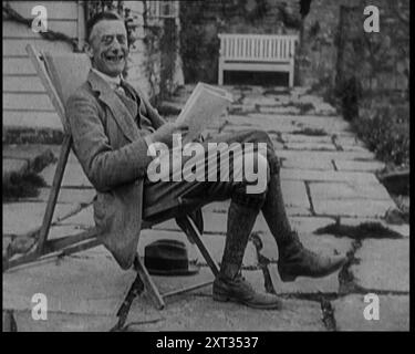 Il Cancelliere britannico dello Scacchiere Joseph Austen Chamberlain legge un giornale seduto su una sedia da giardino, 1920. "...Austin Chamberlain, sorridendo a casa... ma poi, aveva abbastanza da pagare la sua infelice imposta sul reddito". Da "Time to Remember - The Plunge into Peace", 1920 (Reel 2); eventi del 1920 - matrimoni, diritti delle donne, disordini industriali e problemi in Irlanda Foto Stock