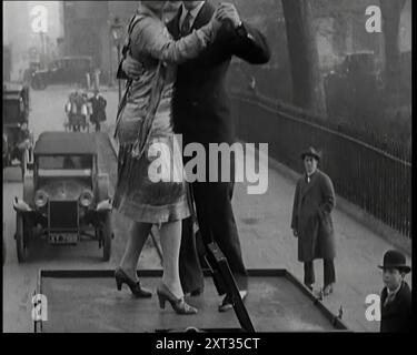 Una coppia che danzava il Charleston sulla cima di un'auto che percorreva una London Street, 1926. Da "Time to Remember 1926 - Short Sharp Shower" ( Reel 4); documentario sul 1926 - General Strike, International Politics, Dancing, Weather and record feats. Foto Stock