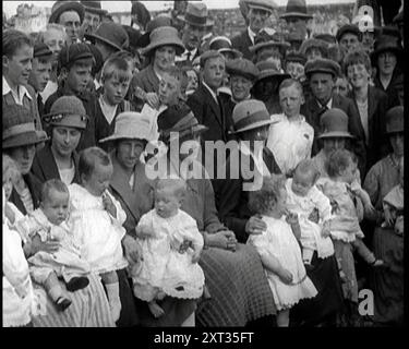 Le madri britanniche sedute con i loro bambini in giro a un Baby Show, 1920. La Gran Bretagna torna alla normalità dopo la prima guerra mondiale. "La pace di avere tutti quei bambini che avresti rimandato di avere per così tanto tempo, finché non hai sentito che il mondo era sicuro per loro". Da "Time to Remember - The Plunge into Peace", 1920 (Reel 4); eventi del 1920 - matrimoni, diritti delle donne, disordini industriali e problemi in Irlanda Foto Stock