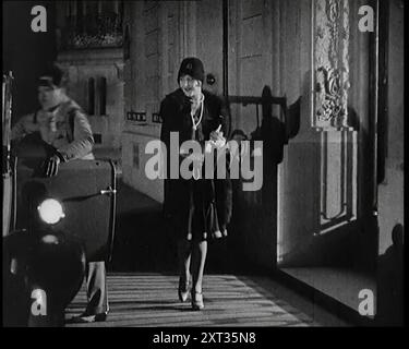 Scena del film "il marito obbligatorio": The Actor Monty Banks Opening the Car Door for a glamour Female Actor, anni '1920 "Senza le popolari concezioni britanniche di comportamento generale francese, è dubbio che queste produzioni avrebbero potuto sopravvivere. Ma per gli inglesi, una donna francese, sullo schermo o fuori, era "ooh la-la, oui oui" e questo era tutto. Da Time to Remember - Came the Dawn, 1925 (Reel 3); dai un'occhiata all'industria cinematografica britannica degli anni '1920 - clip di grandi film muti e notiziari. Foto Stock