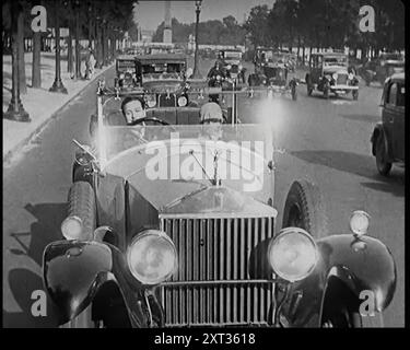 Scena del film "il marito obbligatorio": L'attore Monty Banks alla guida di un'auto con un passeggero femminile su una strada trafficata, anni '1920 "...la Francia dello sceneggiatore era una delle auto costose guidate da cani gay francesi come Monty Banks, che era italiano di origine comunque. Correndo sopra animali domestici, e/o bambini, la trama è stata condotta nei canali appropriati, con introduzioni tra coppie sposate, che hanno messo in moto un altro tipo di tumulto". Da Time to Remember - Came the Dawn, 1925 (Reel 3); dai un'occhiata all'industria cinematografica britannica degli anni '1920 - clip di grandi film muti e n Foto Stock