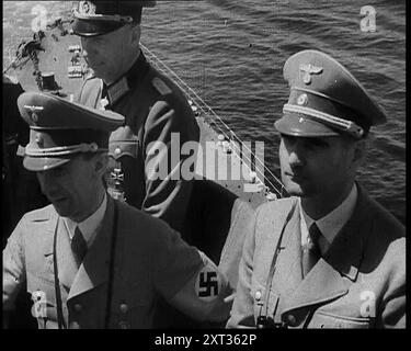 Dr. Josef Goebbels, Rudolf Hess, e ufficiale tedesco a bordo di una nave da guerra italiana, 1937. "Sul ponte di una nave da battaglia nel Mediterraneo, il leader di tutti i tedeschi è intrattenuto dal leader di tutti gli italiani, (e non intendiamo il re d'Italia). I ragazzi erano tutti lì insieme, ispezionando la flotta italiana e stimando la sua potenza di combattimento in caso ci fossero... problemi. Da Time to Remember - Sense of Values, 1937 (Reel 1); documentario sugli eventi del 1937, guerra in Estremo Oriente, costruire fino alla guerra in Europa. Foto Stock