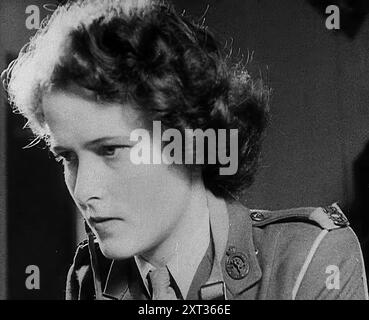 Una donna che gestisce una radio, 1940 anni. Regno Unito durante la seconda guerra mondiale: Monitoraggio dei bombardamenti tedeschi. "Ottanta più [aerei nemici], assemblando su aree Amiens, Abbeville. Altri sessanta, vicino a Dieppe. Controllo consigliato". I primi rapporti radar tendono verso la probabilità che gli obiettivi siano aeroporti di caccia a est e a sud-est di Londra. In altre parole, per Control, sembra lo stesso di stamattina. Ma e' troppo presto per giudicare. Potrebbe essere Londra stessa. "Tutti gli squadroni disponibili sono pronti. Sentiamo dal corpo degli osservatori il prima possibile". Da "T Foto Stock