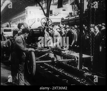 Un gruppo di civili maschi che costruiscono un'auto come una folla di persone che guardano. Dietro la folla c'è la locomotiva n. 866 N Class della Southern Railway, 1924. Da "Time to Remember - A Trip to Europe", 1924 (Reel 3); uno sguardo alla vita politica e sociale in Europa e oltre nel 1924. Foto Stock