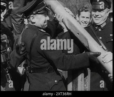 Ufficiali tedeschi maschi che rimuovono una Barriera a un Checkpoint al confine tra Germania e Austria, 1938. Da "Time to Remember - Wind Up Week", 1938 (Reel 1); documentario sul 1938 - le persone diventano consapevoli della crescente minaccia della guerra. Foto Stock