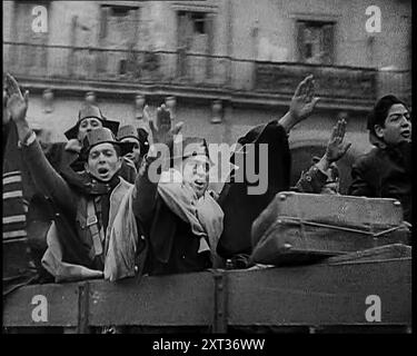 Combattenti spagnoli sul retro di un camion che fa saluti fascisti e celebra la vittoria dei combattenti nazionalisti che prendono Madrid con la maggior parte di loro indossando un Tricornio celebrativo della Guardia civile spagnola, 1939. Da "Time to Remember - The Reluctant Warriors", 1939 (Reel 1); documentario sugli eventi del 1939 - i preparativi per la guerra e poi scoppiano le ostilità. Foto Stock