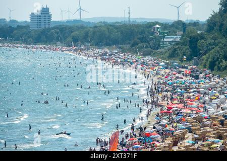 Voller Sommerstrand in Scharbeutz Das Bild zeigt einen vollen Strand in Scharbeutz an der heißen an einem sonnigen Ostseeküste Sommertag. Der Strand ist dicht besetzt mit Strandkörben, bunten Sonnenschirmen und zahlreichen Badegästen, die das warme Wetter genießen. Im Wasser tummeln sich Menschen, die schwimmen oder einfach im seichten Wasser stehen. An vielen Orten in Deutschland könnte es heute der bislang heißeste Tag des Jahres werden. Scharbeutz Schleswig-Holstein Deutschland *** Spiaggia estiva completa a Scharbeutz l'immagine mostra una spiaggia piena a Scharbeutz, sulla costa del Mar Baltico, su un caldo Foto Stock