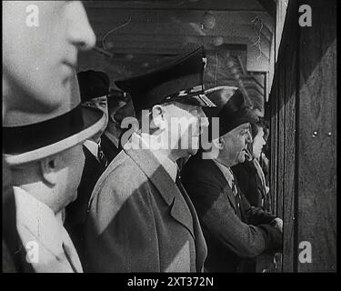 Un primo piano di Adolf Hitler che guarda al mare da un ponte a bordo della nave da crociera "forza attraverso la gioia" The Robert Ley con passeggeri da entrambi i lati di lui, incluso Robert Ley stesso, 1939. Da "Time to Remember - The Reluctant Warriors", 1939 (Reel 1); documentario sugli eventi del 1939 - i preparativi per la guerra e poi scoppiano le ostilità. Foto Stock