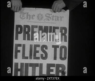 Due mani con il titolo del giornale Star 'PREMIER VOLA A HITLER', 1938. Da "Time to Remember - Wind Up Week", 1938 (Reel 3); documentario sul 1938 - le persone diventano consapevoli della crescente minaccia della guerra. Foto Stock