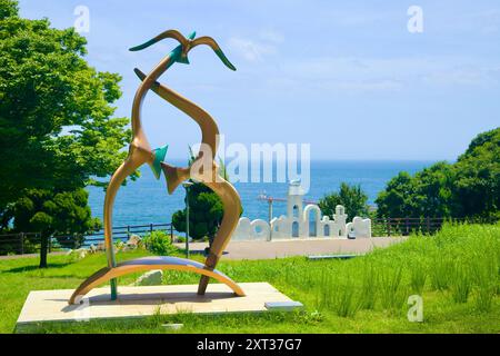 Contea di Uljin, Corea del Sud - 27 luglio 2024: Una scultura astratta si erge in primo piano nel Deunggi Mountain Park, con una splendida vista del Mare Orientale A. Foto Stock
